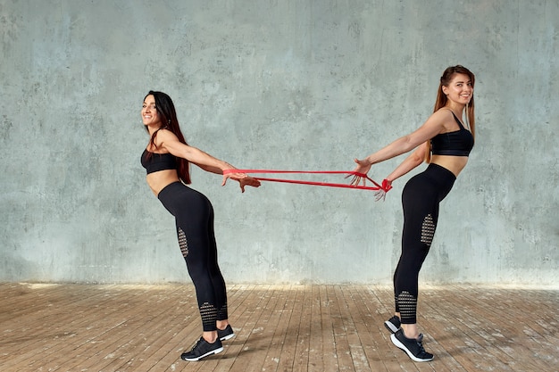 Modelos de fitness fazendo exercícios com elástico em um estúdio de fitness. s Foto Premium