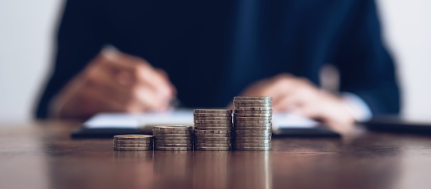 Moeda para empilhar dinheiro, crescimento do negócio financeiro. homens está assinando documentos. Foto Premium