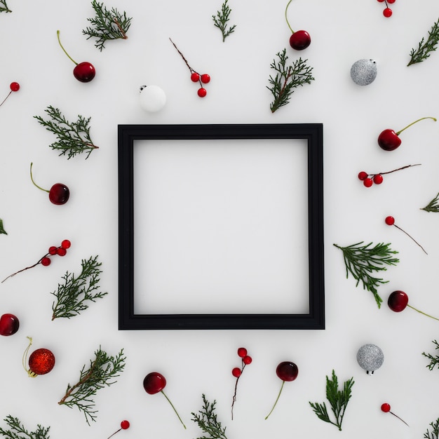 Moldura preta com padrões feitos com folhas de pinheiro e bolas de natal decorativas Foto gratuita
