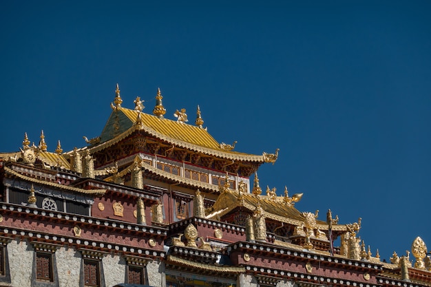 Mosteiro de ganden sumtseling (mosteiro de songzanlin) com lago e céu azul claro, shangri-la, china Foto Premium