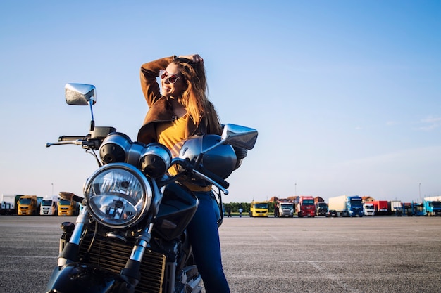 Motociclista Feminina Em Uma Jaqueta De Couro Sentada Em Uma Moto