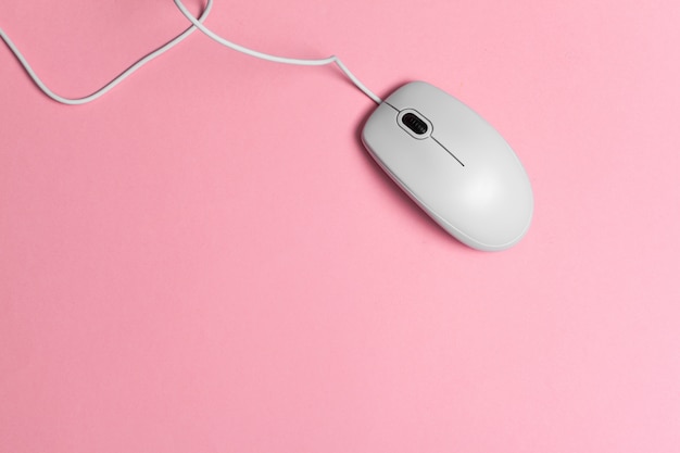 Mouse de computador com um cabo sobre um papel rosa Foto Premium