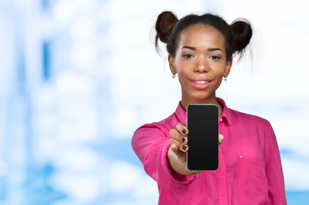 Mulher afro-americana, mostrando um telefone móvel Foto Premium