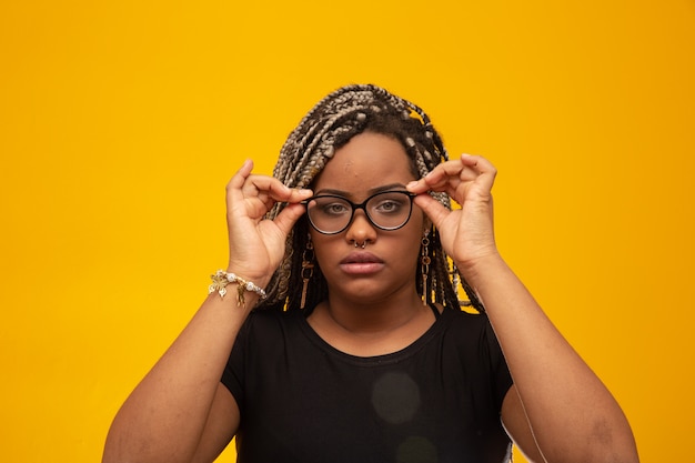 Mulher afro-americana nova bonita com cabelo do dread e eyeglasses no amarelo Foto Premium