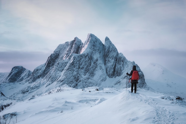 Mulher alpinista em pé no topo do pico segla uma montanha majestosa