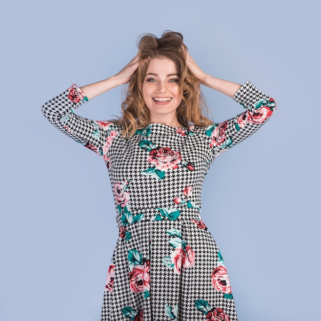 Mulher apaixonada positiva no vestido com as mãos no cabelo Foto gratuita