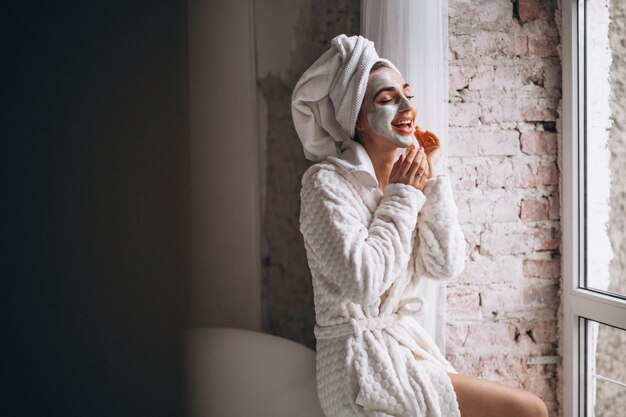 Mulher, aplicando, facial, maskin, banheiro Foto gratuita