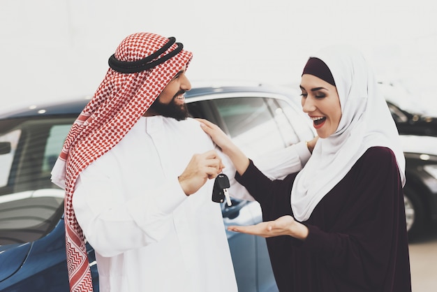 Mulher árabe muito feliz tem as chaves do carro do homem amoroso. Foto Premium