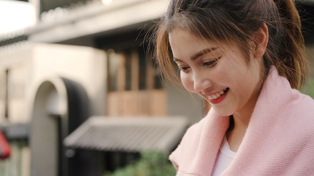 Mulher asiática alegre do blogger do mochileiro que usa o smartphone para o sentido e olhando no mapa de lugar ao viajar no bairro chinês no pequim, china. Foto gratuita