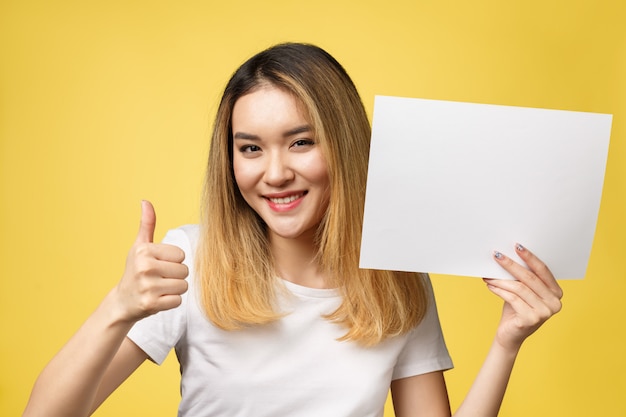 Mulher asiática bonita nova atrativa do estudante que prende o livro branco em branco. Foto Premium