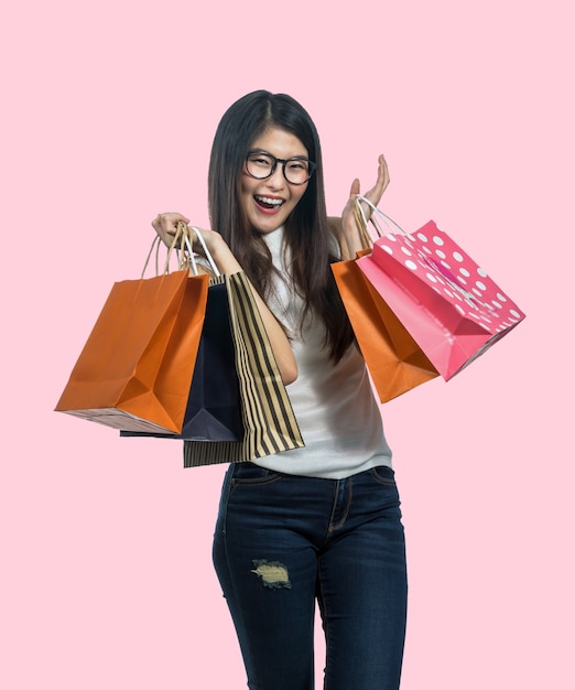 Mulher asiática nova feliz que compra no sentimento feliz e que guarda o saco de papel do produto Foto Premium