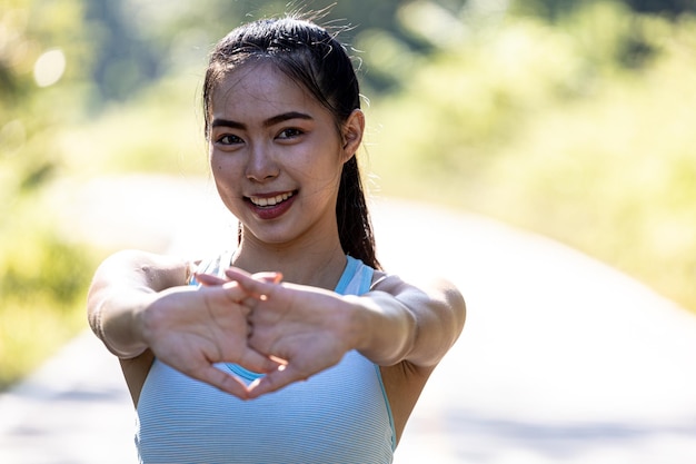 Mulher asiática se aquecendo antes de correr ela está correndo em um