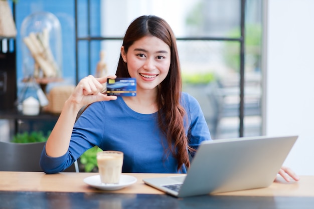 Mulher asiática tomando café e trabalhando com o computador ...