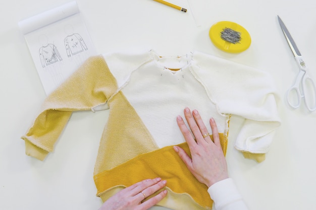 Mulher com freelancer de cabelos loiros ou designer de moda ou alfaiate, trabalhando em design ou projecto com tecidos coloridos na oficina Foto Premium