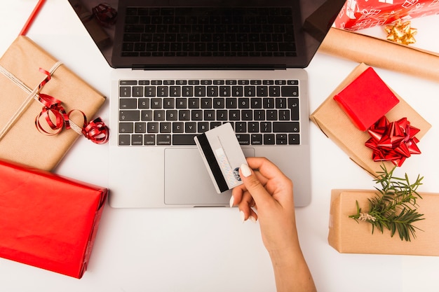 Mulher comprando presentes de natal on-line com presentes na mesa Foto gratuita