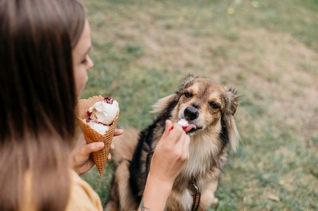 Mulher dando sorvete para o cachorro | Foto Premium