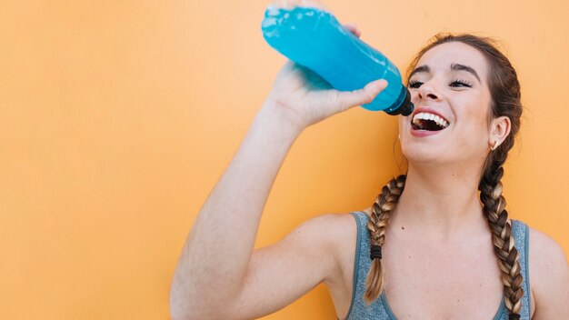 Mulher desportiva com bebida azul Foto Grátis