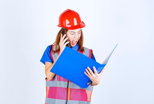 Mulher Engenheira De Uniforme E Capacete Vermelho Segurando Uma Pasta