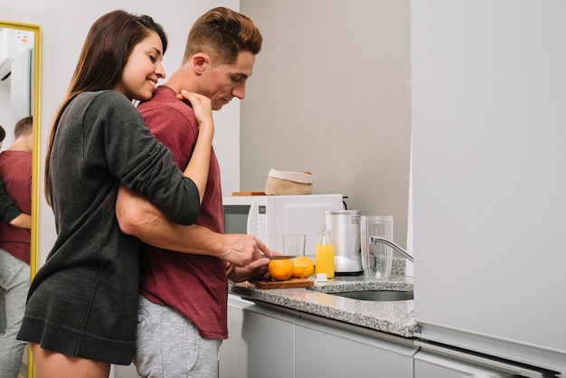 Mulher Feliz Abraando Homem Detrs Enquanto Ele Corte Laranja