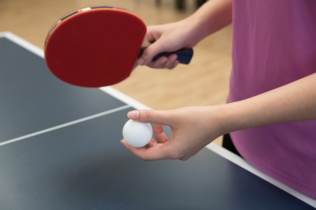 Mulher, jogando tênis tabela, com, a, raquete, e, pingue pong, bola, em, posição servindo Foto Premium