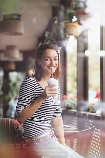 Mulher jovem, bebendo, milkshake Foto gratuita