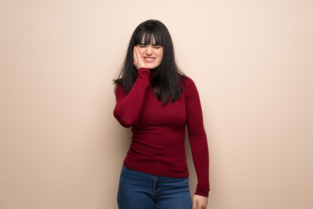 Mulher jovem, com, vermelho, gola alta, com, toothache Foto Premium