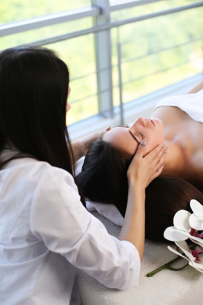 Mulher Jovem E Bonita Relaxando Com Massagem De Mãos Em Spa De Beleza Foto Premium 