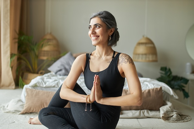 Mulher feliz fazendo yoga de Home-Office