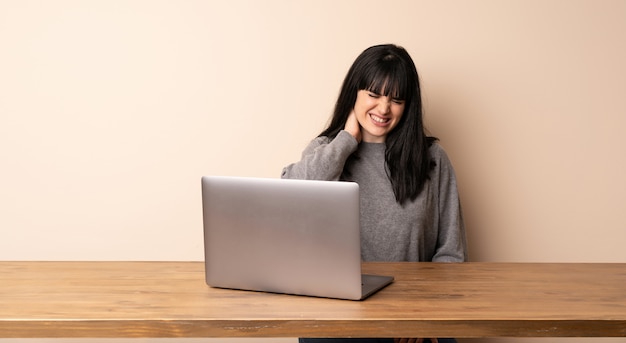 Mulher jovem, trabalhando, com, dela, laptop, com, neckache Foto Premium