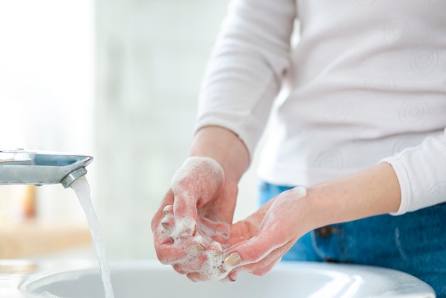 Mulher lavando mãos com sabonete