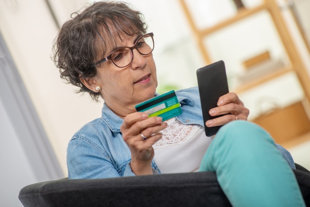 Mulher morena sênior, compras com smartphone e internet Foto Premium