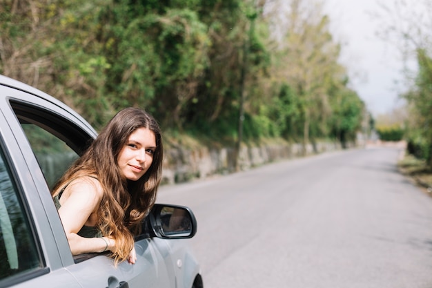 Mulher olhando pela janela do carro aberta Foto gratuita