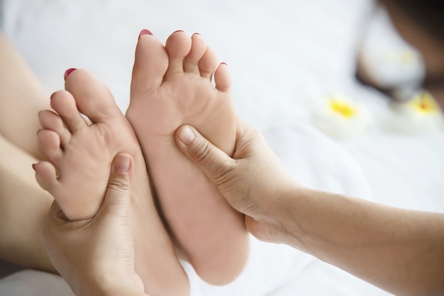 Mulher, recebendo, pé, massagem, serviço, de, masseuse, cima, em, mão, e, pé, -, relaxe, em, pé, massagem, terapia, serviço, conceito Foto gratuita