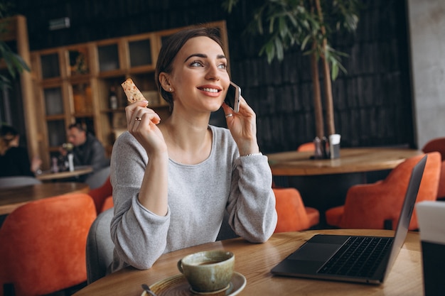 Mulher, sentando, em, um, café, café bebendo, e, trabalhar, um computador Foto gratuita