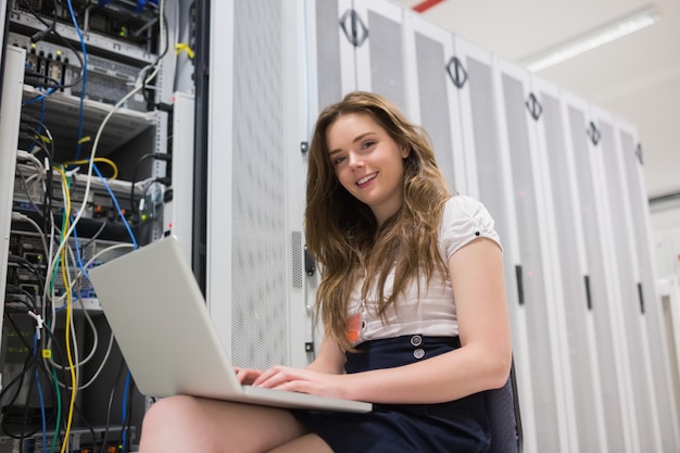 Mulher sorridente, com, laptop, trabalhando, com, servidores Foto Premium