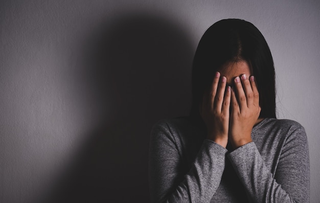 Mulher Triste Fecha O Rosto E Chora Mulher Triste Sentada Sozinha Em Uma Sala Vazia Foto Premium