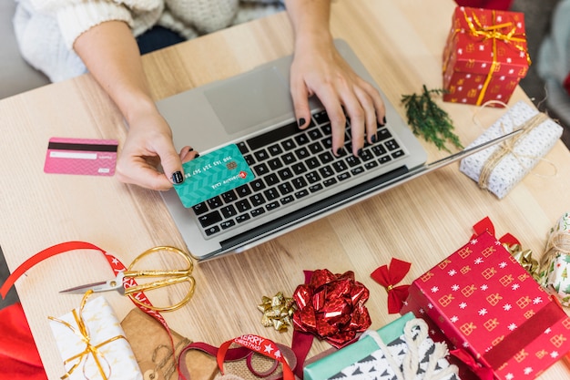 Mulher, usando computador portátil, com, cartão crédito Foto gratuita