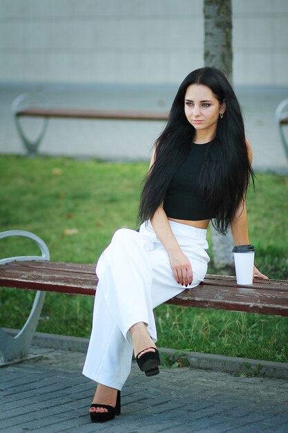 Mulher vai viajar com bagagem no aeroporto internacional de lviv e beber café Foto Premium