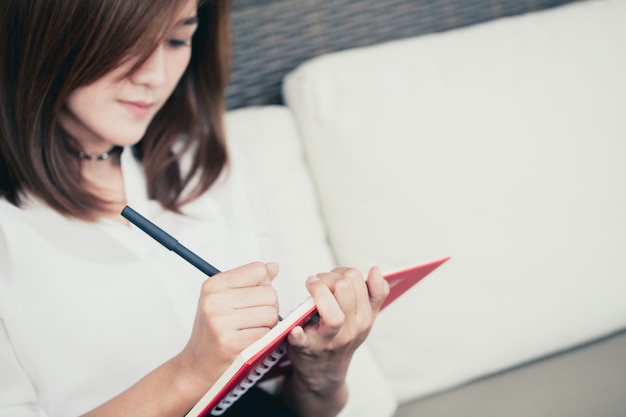 Mulheres de funcionamento asiáticas que escrevem o memorando da nota da empresa do projeto com copyspace. Foto Premium