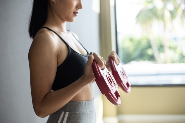 Mulheres exercitando com duas placas de peso com halteres Foto gratuita