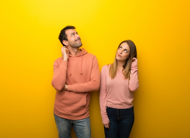 No dia dos namorados Grupo de duas pessoas no fundo amarelo pensando uma idÃ©ia enquanto coÃ§ando a cabeÃ§a Foto Premium