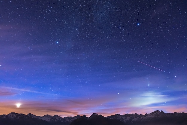 Noite nos alpes sob o céu estrelado e o luar Foto Premium