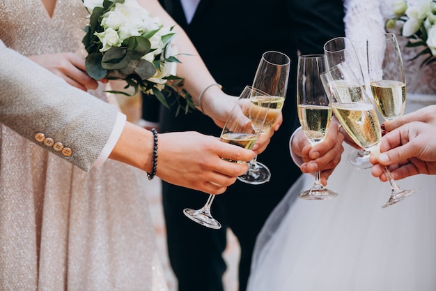 Noiva com noivo bebendo champaigne em seu casamento Foto gratuita