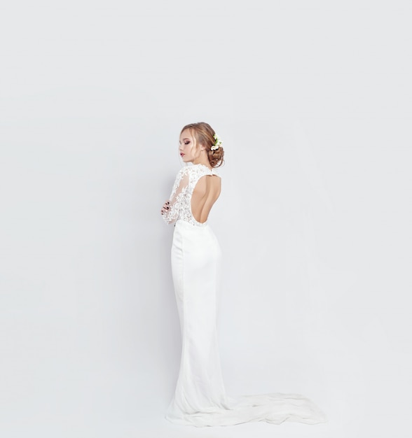 Noiva em vestido de noiva branco longo em um branco Foto Premium