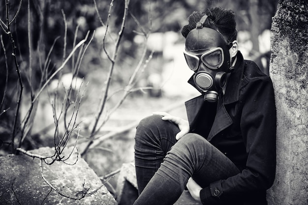 O cara de casaco e máscara de gás. retrato pós-apocalíptico asiático mascarado da radiação. o menino é coreano com uma máscara de envenenamento por gases. máscara pós-nuclear no asiático. Foto Premium