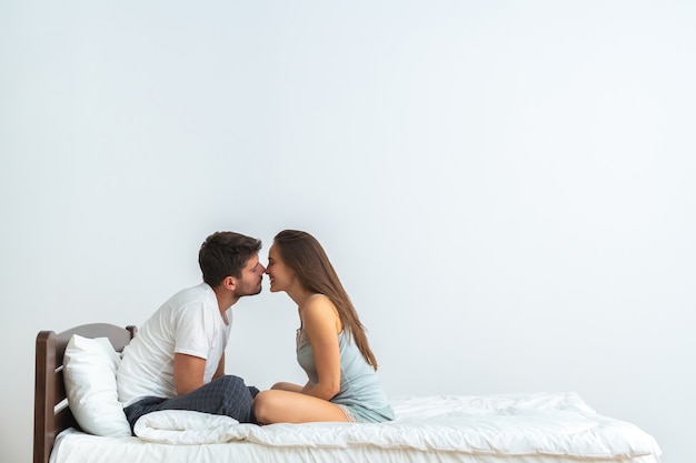 O Casal Feliz Na Cama Se Beijando No Fundo Branco Foto Premium