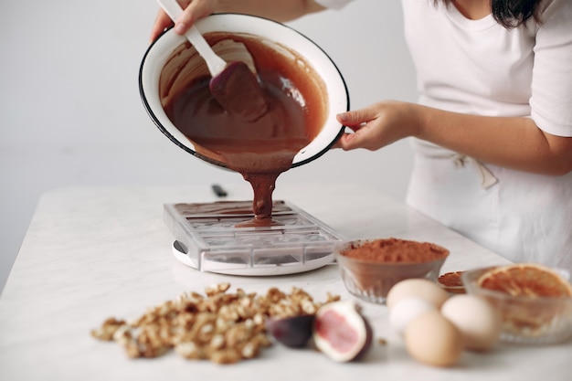 O confeiteiro mistura os ingredientes. a senhora está preparando a sobremesa. a mulher faz um bolo. Trabalhe 