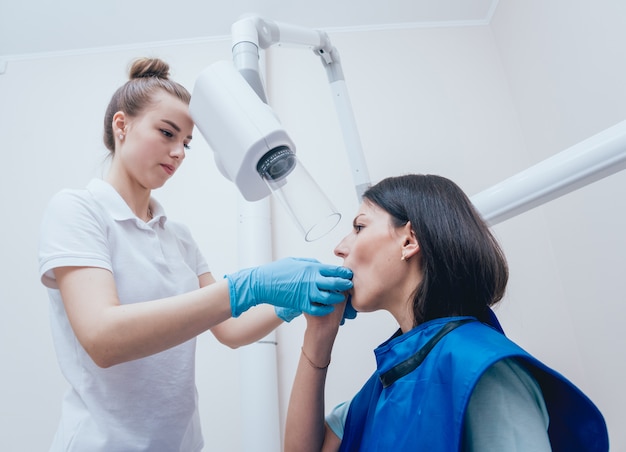 O Dentista Faz A Imagem Do Raio X Para A Jovem Mulher Na Clnica Dental