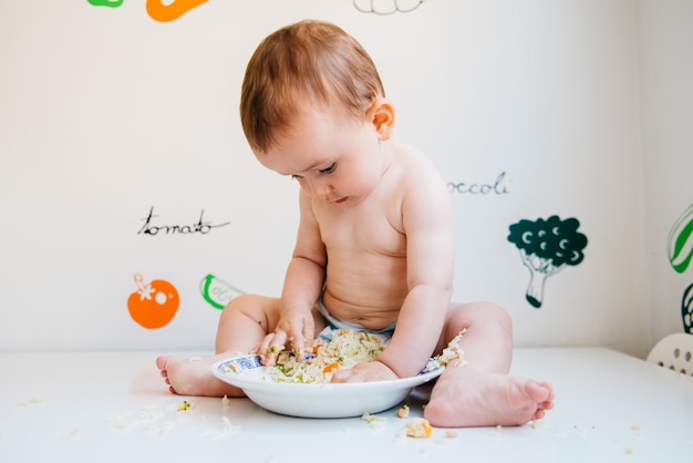 O desmame conduzido pelo bebê é um método de alimentação complementar no qual o próprio bebê, a partir dos 6 meses de idade, leva alimentos integrais à boca. Foto Premium