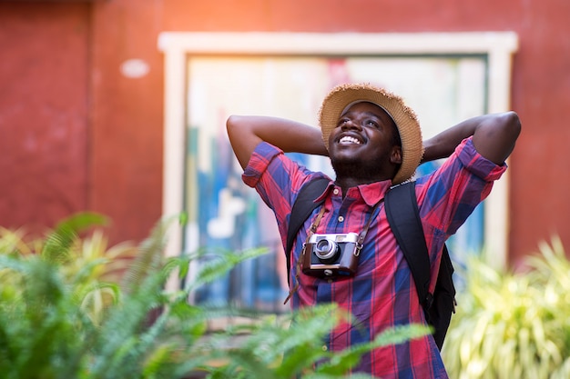 O homem africano do turista sente feliz com lugar do curso na cidade do cenário. Foto Premium